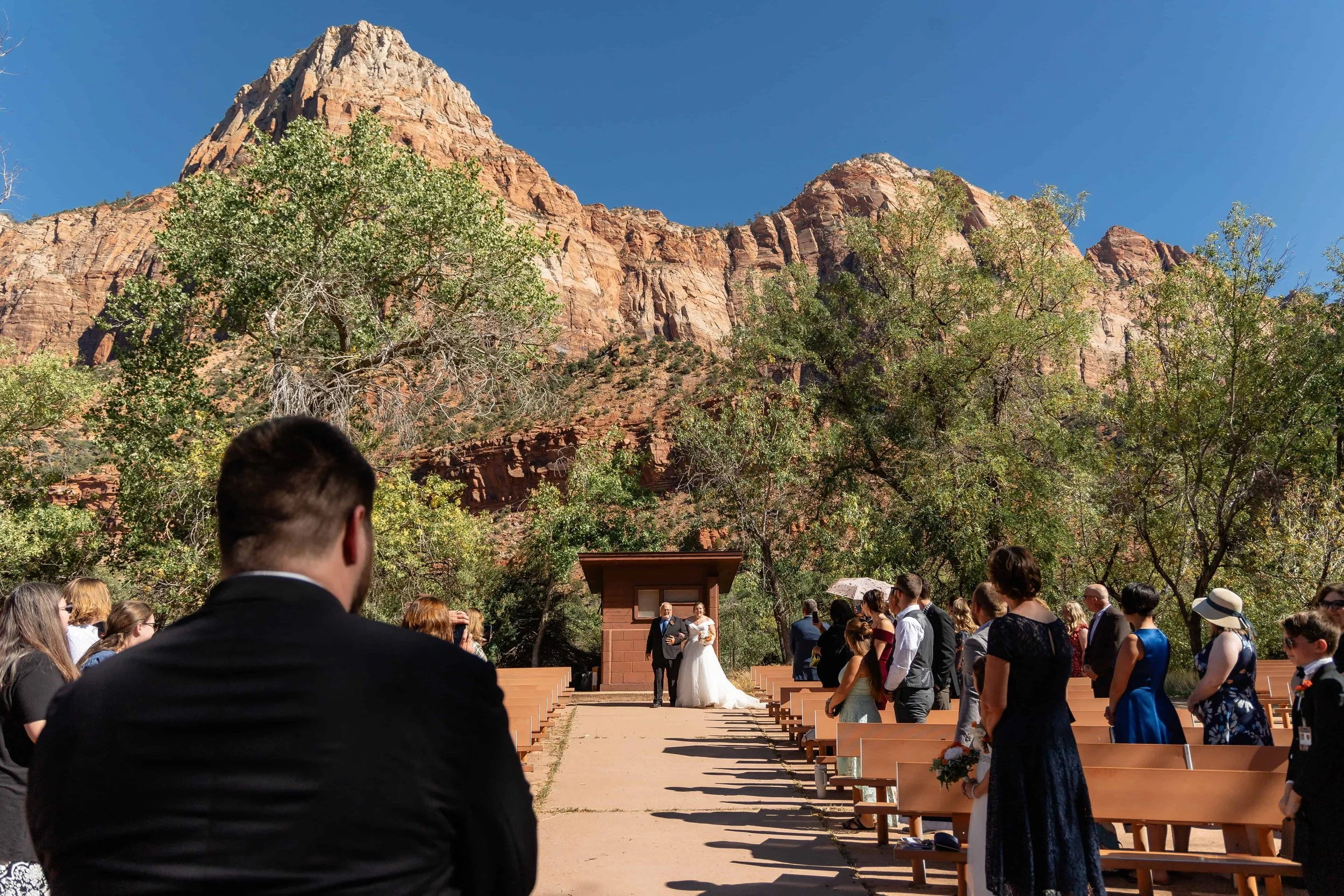 Bride and father walk into wedding ceremony at zion south campground amphitheater