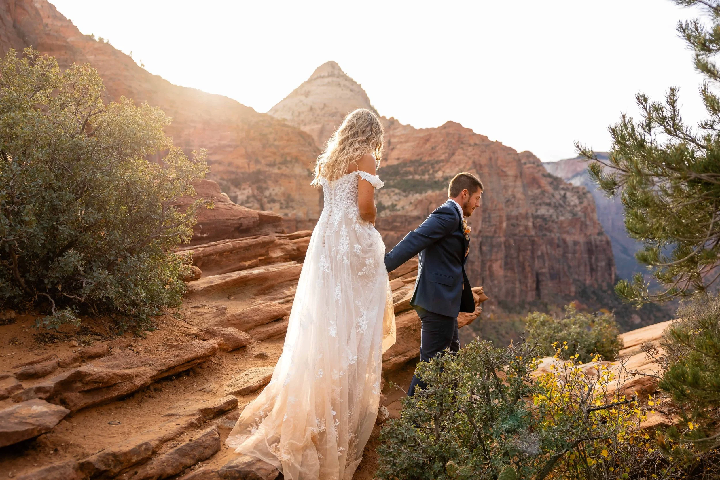bride and groom walk together at canyon overlook in fall zion