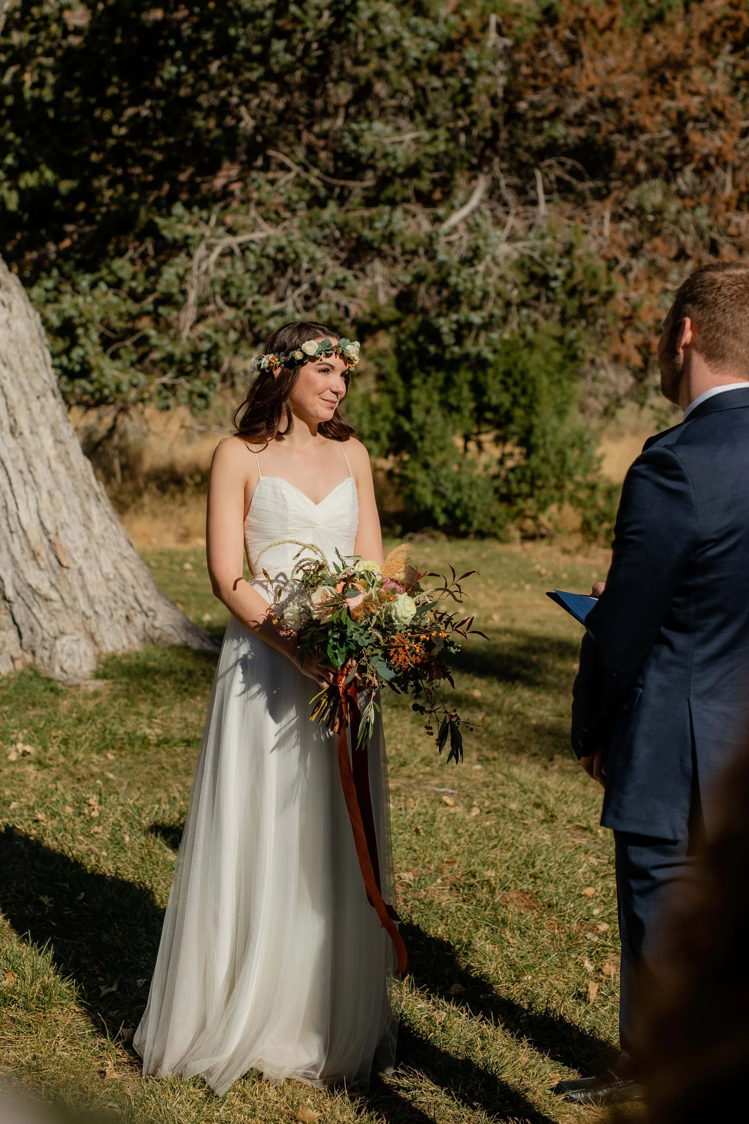 bride holds bouquet during wedding ceremony at nature center