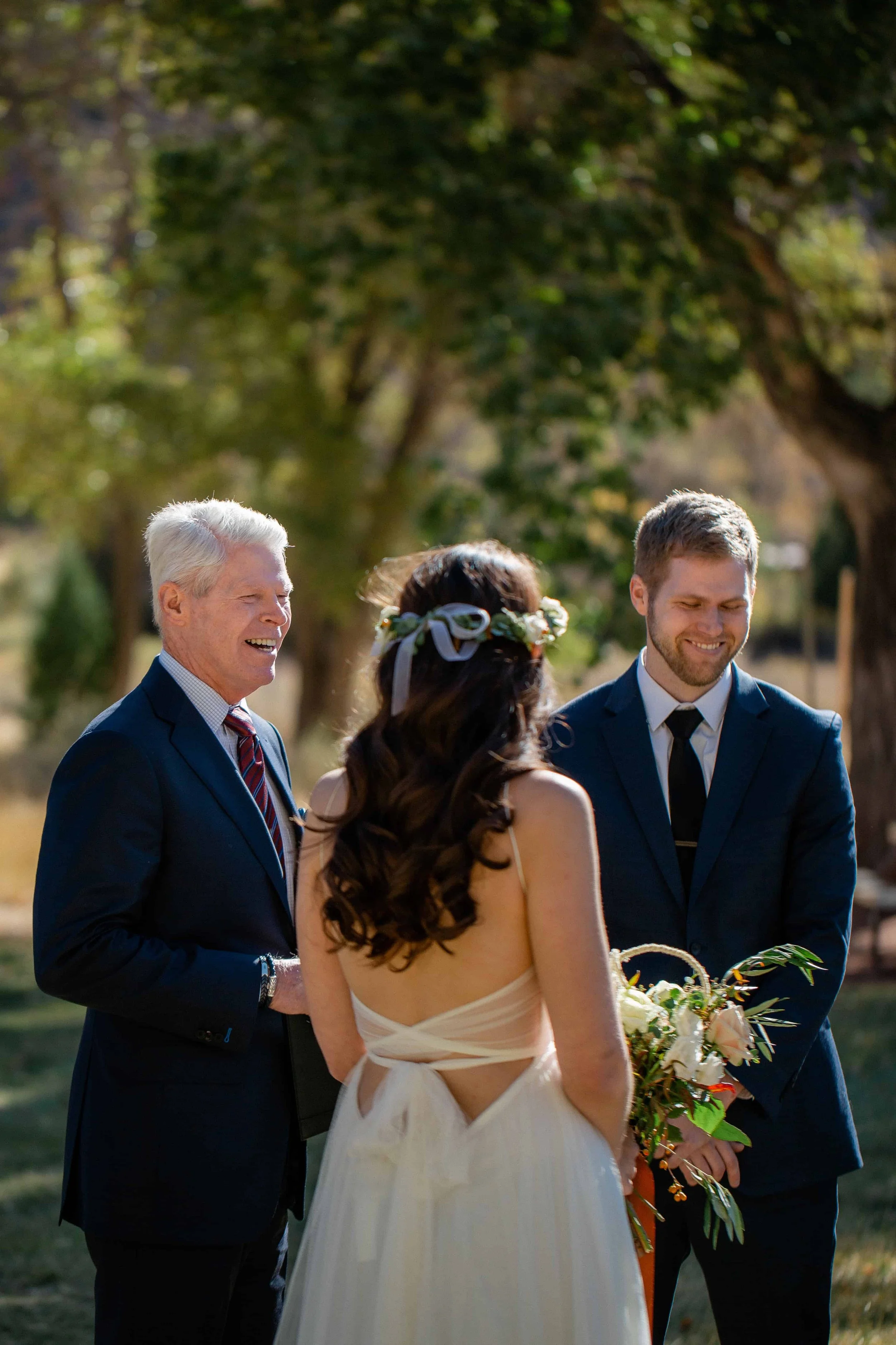 Groom and officiant smile during intimate wedding ceremony at nature center