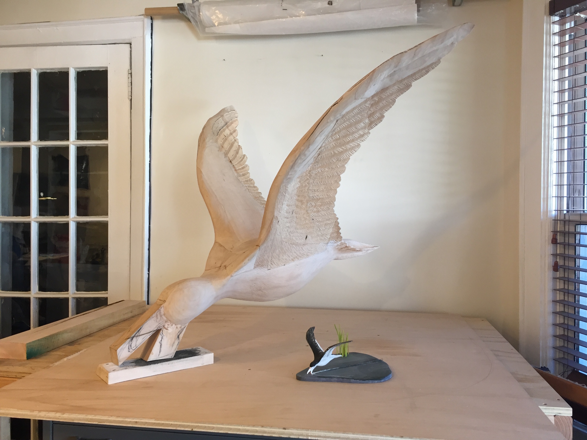 The maquette and full scale work next to each other. Next steps involve buying more wood and carving the base, along with continued carving on the wings, the body and the beak.. 