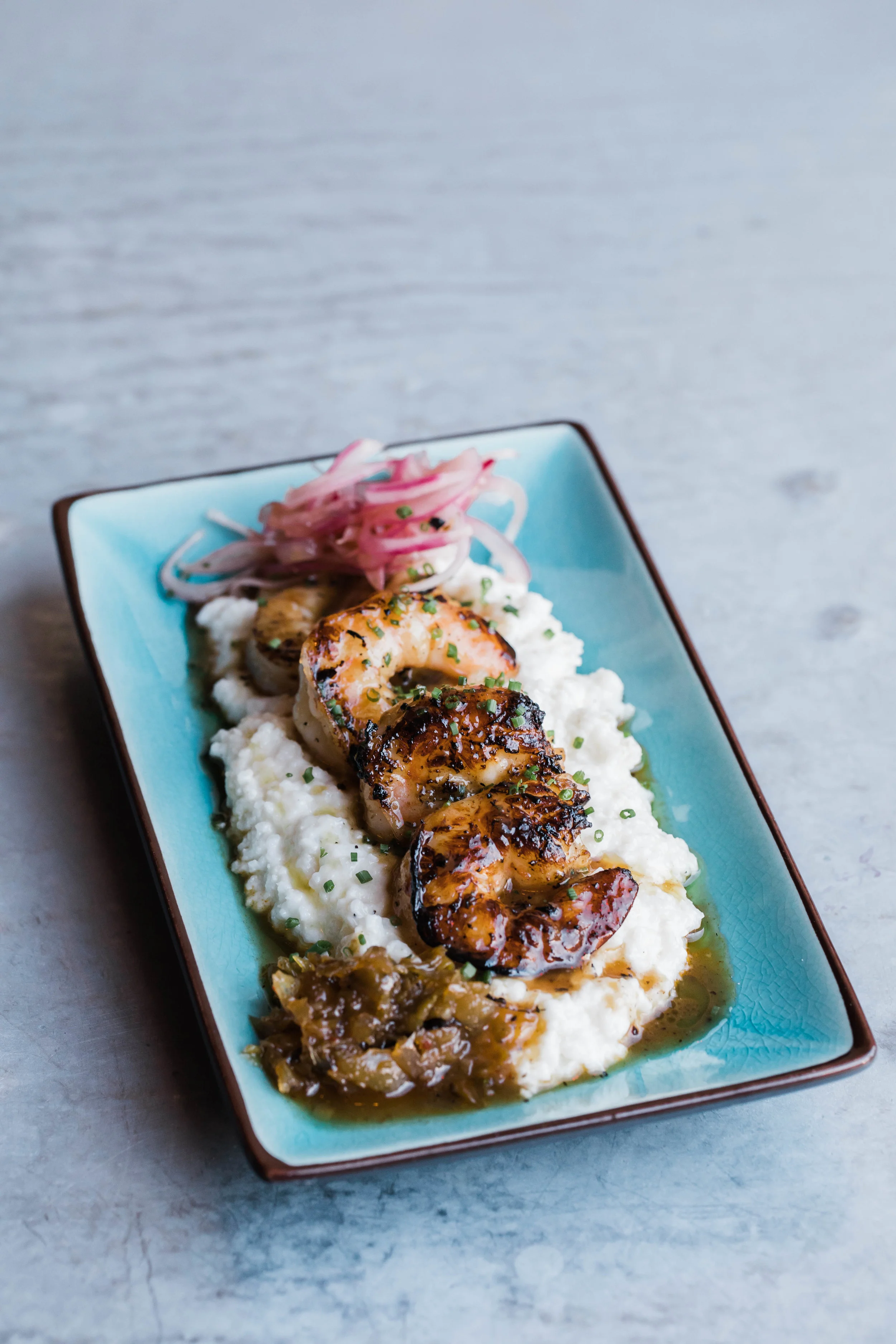 Grilled Jerk Shrimp Creamy Cheddar Grits/ Pepper Jelly/ Pickled Red Onion