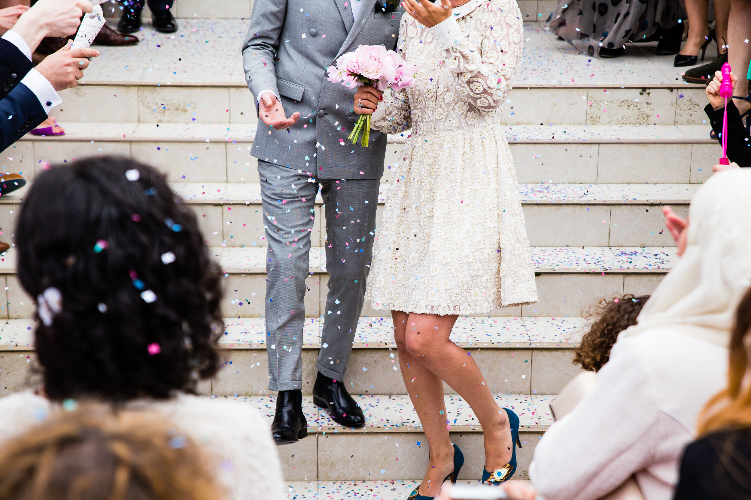 Bride and groom throw confetti at a wedding