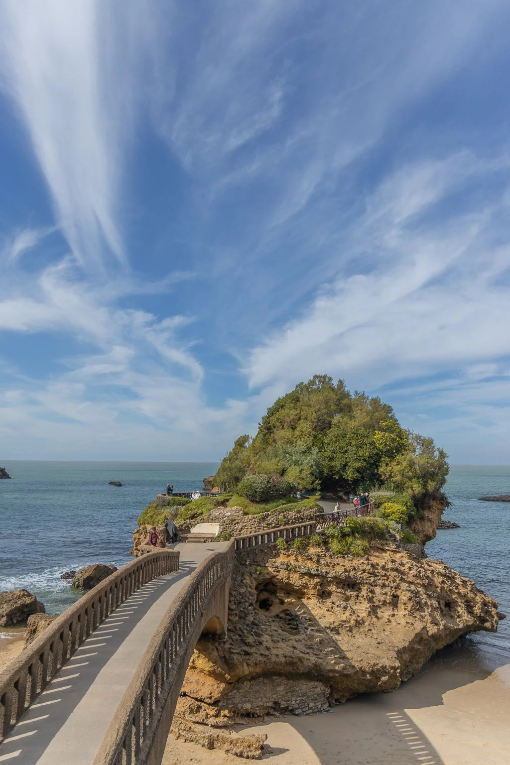 Iconic Rocher de la Vierge footbridge and statue overlooking dramatic ocean waves in Biarritz
