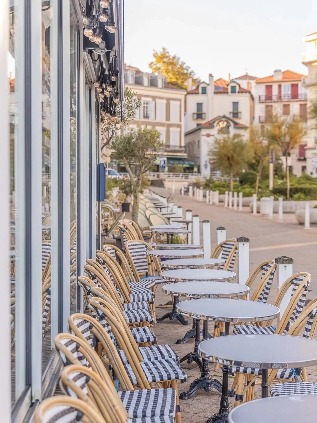 Outdoor restaurant terrace in Biarritz in a cute place, sun umbrellas, and relaxed coastal atmosphere