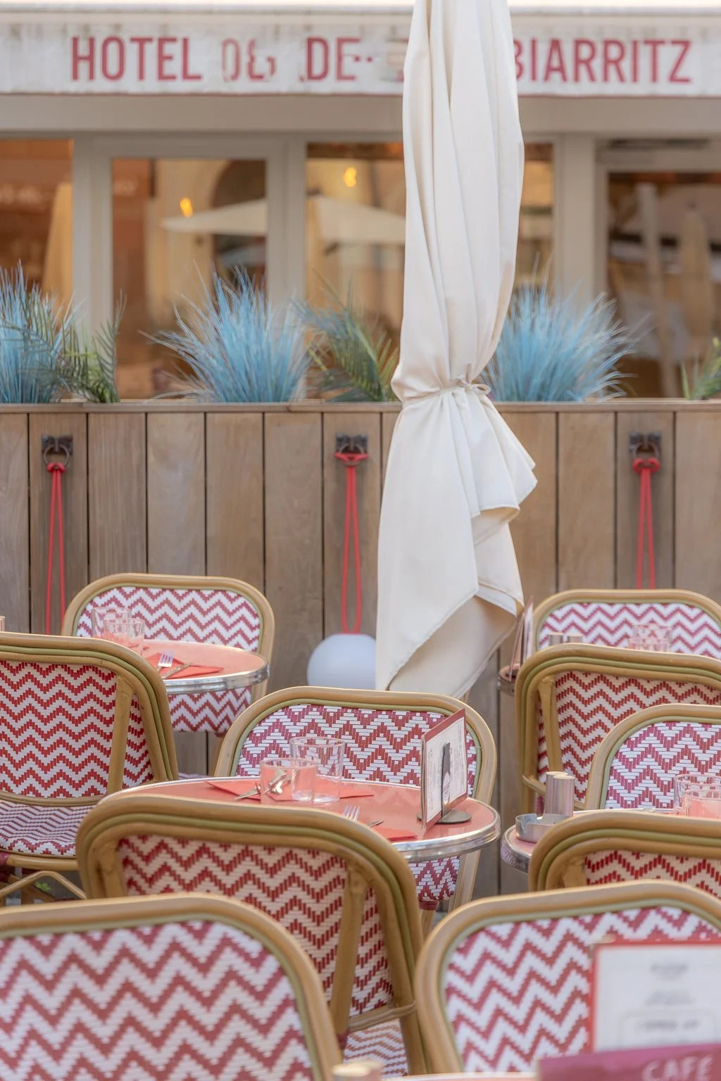 Outdoor restaurant terrace in Biarritz with sea view, sun umbrellas, and relaxed coastal atmosphere