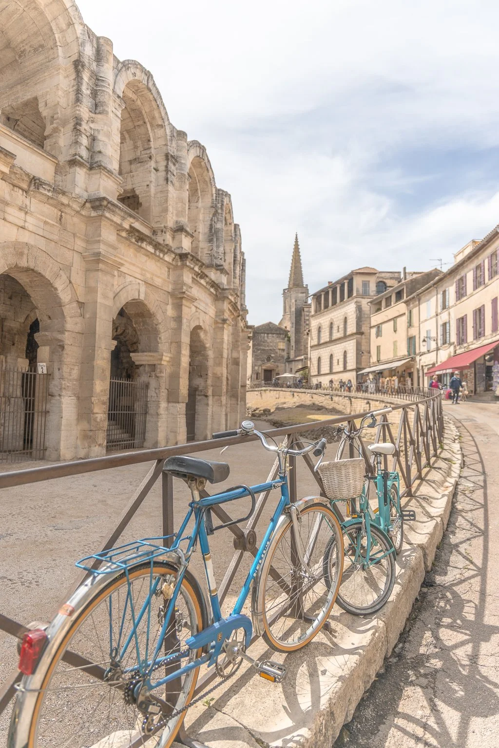 View of the Roman Amphitheatre in Arles with sunlight illuminating the ancient stone arches