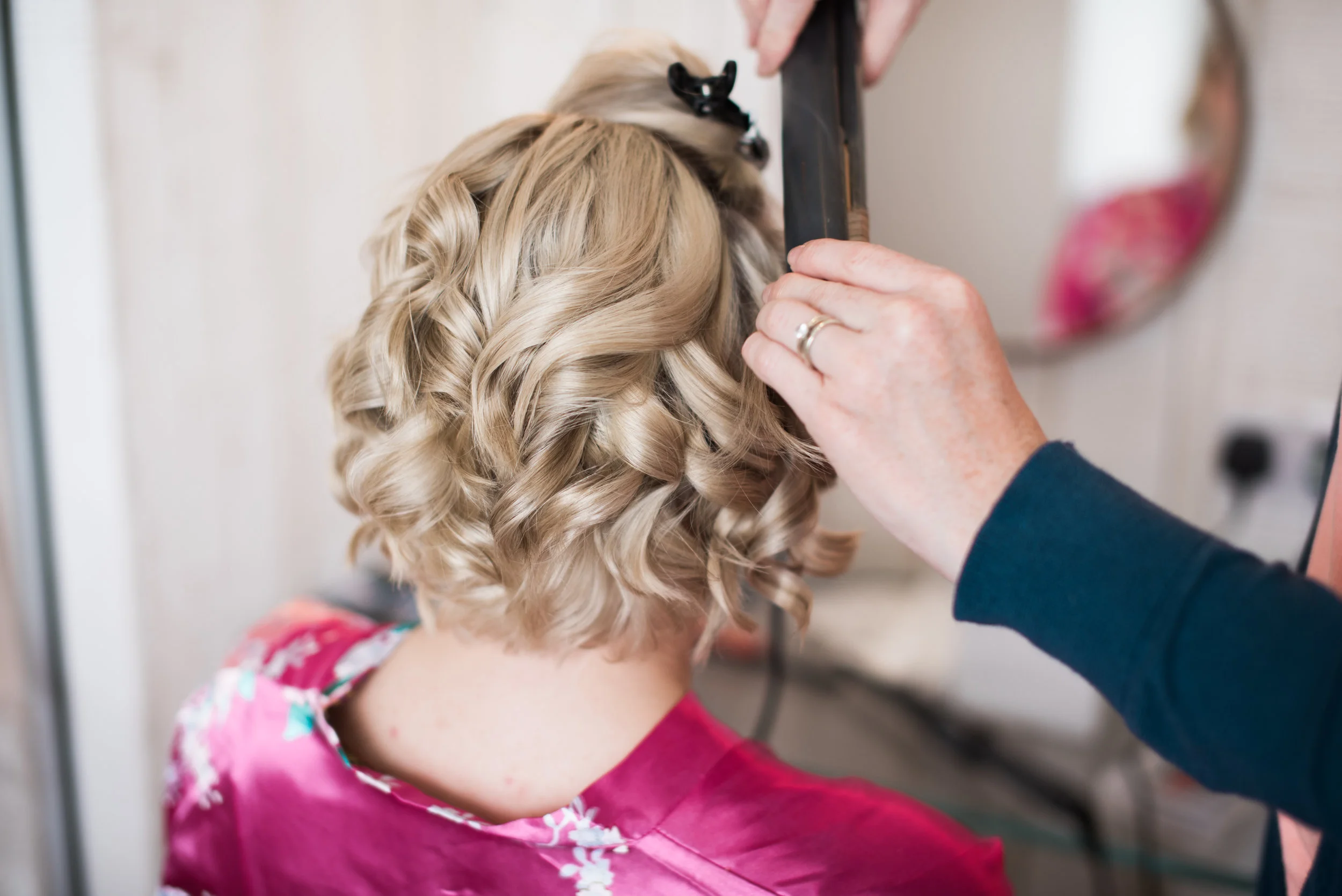 bridesmaid having her hair curled.