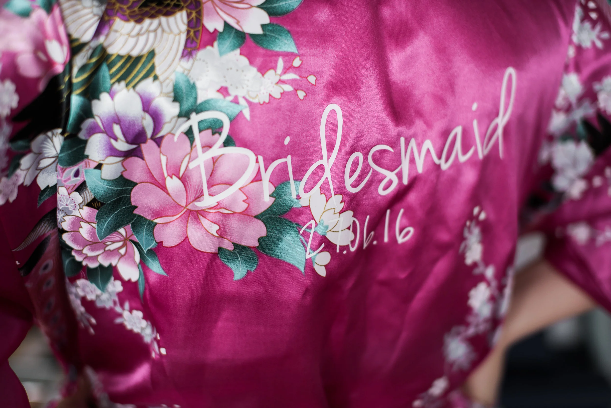 Closeup photography of the bridesmaids dressing gown with name and date of wedding.