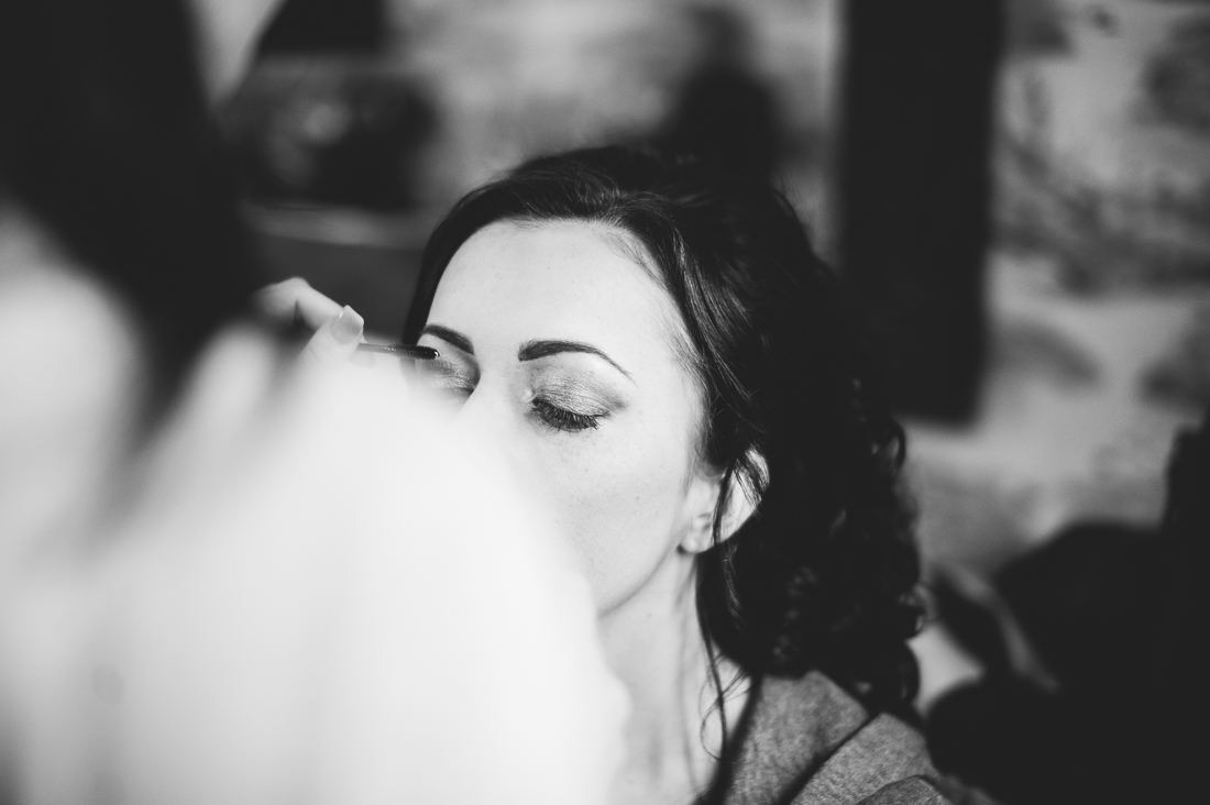 Bride having her make up done on the morning of her wedding. Black and white photo.