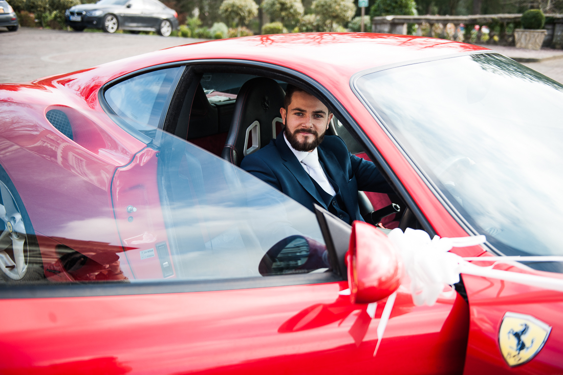 Groom arriving at Eaves Hall in a red Ferrari 
