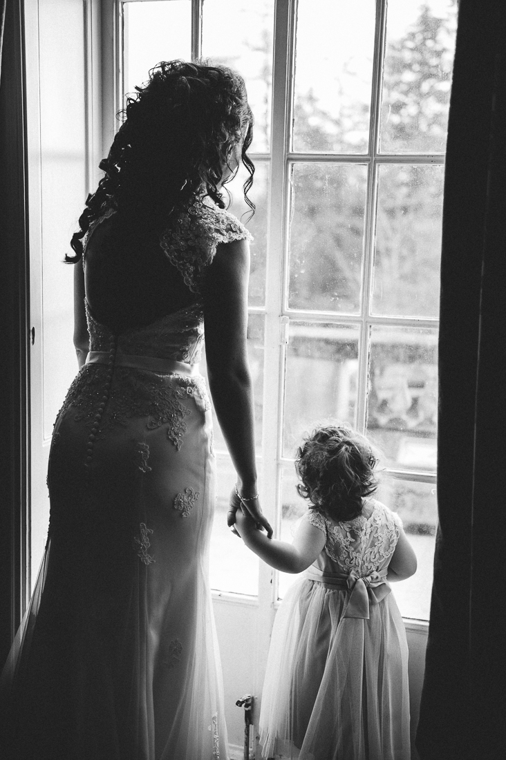 Bride and her daughter looking out of the window at Eaves Hall in Clitheroe. Lancashire wedding photography