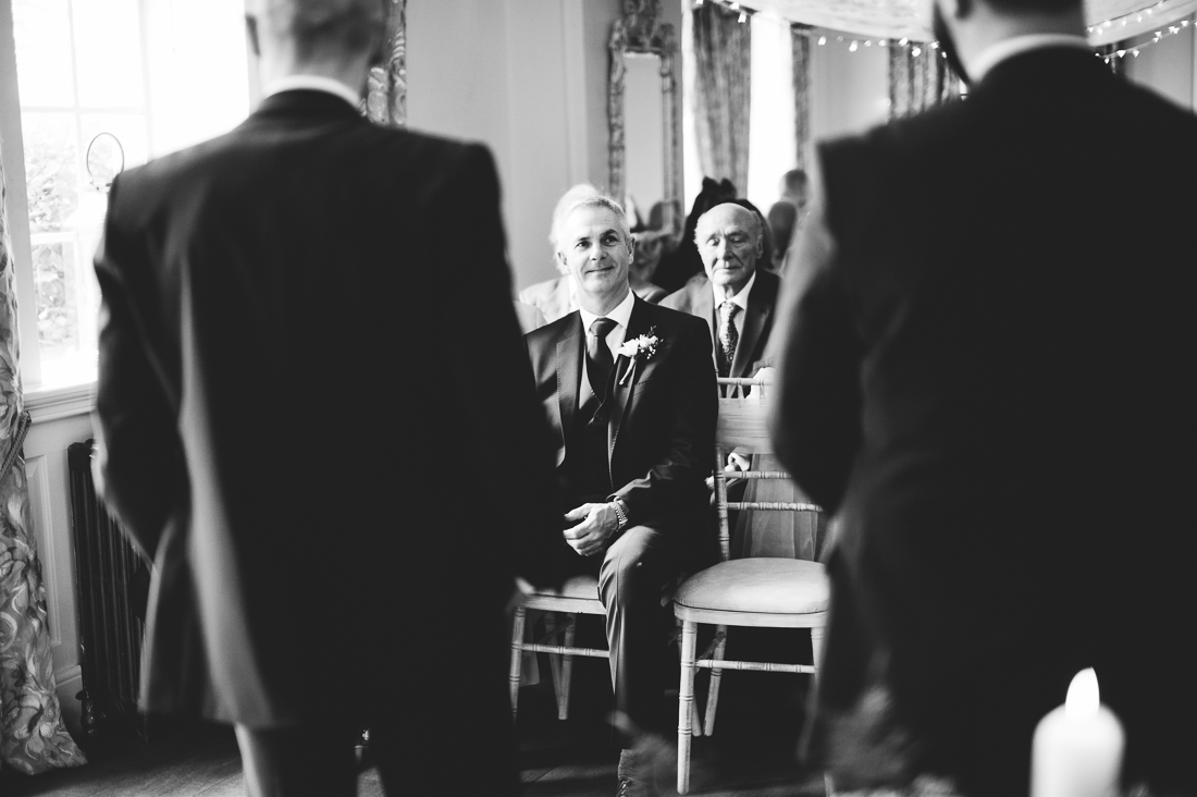 Documentary photography of Grooms father laughing with the groom before bride arrives