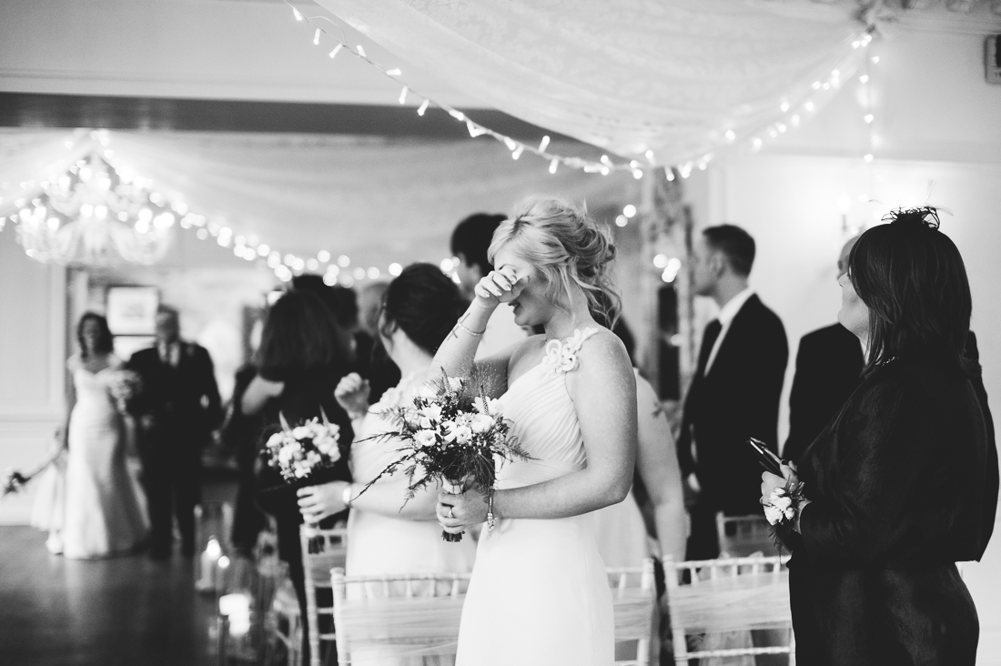Documentary photography of the bridesmaid crying as the bride enters the room 