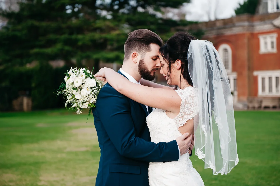 Intimate portrait of the bride and groom on the grass at Eaves Hall