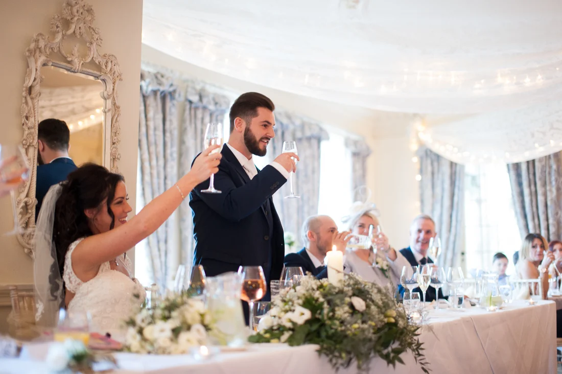 Bridal party raising a toast during the speeches at Eaves Hall