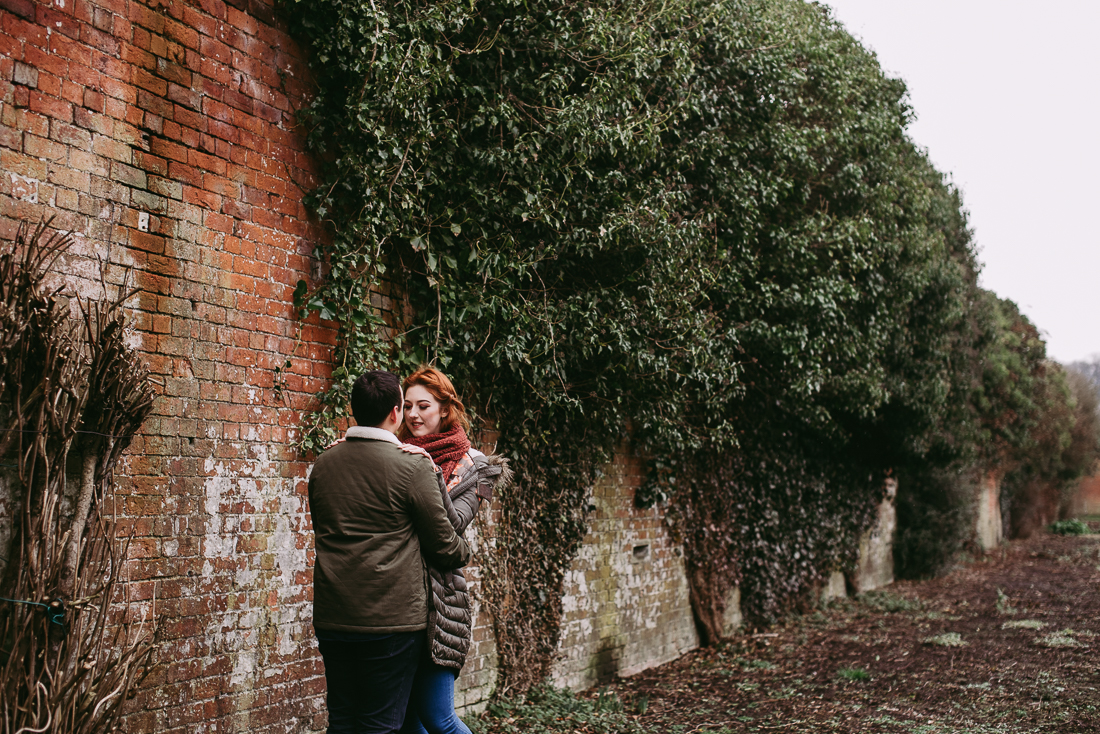 Documentary photo of couple in front of red brick wall. Haigh Hall, Lancashire 