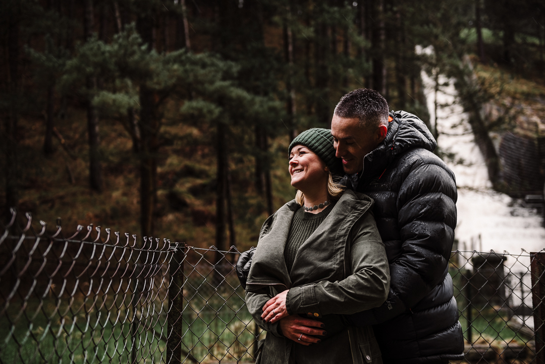 Natural shot of couple hugging in front of a river at Hurstwood, Burnley