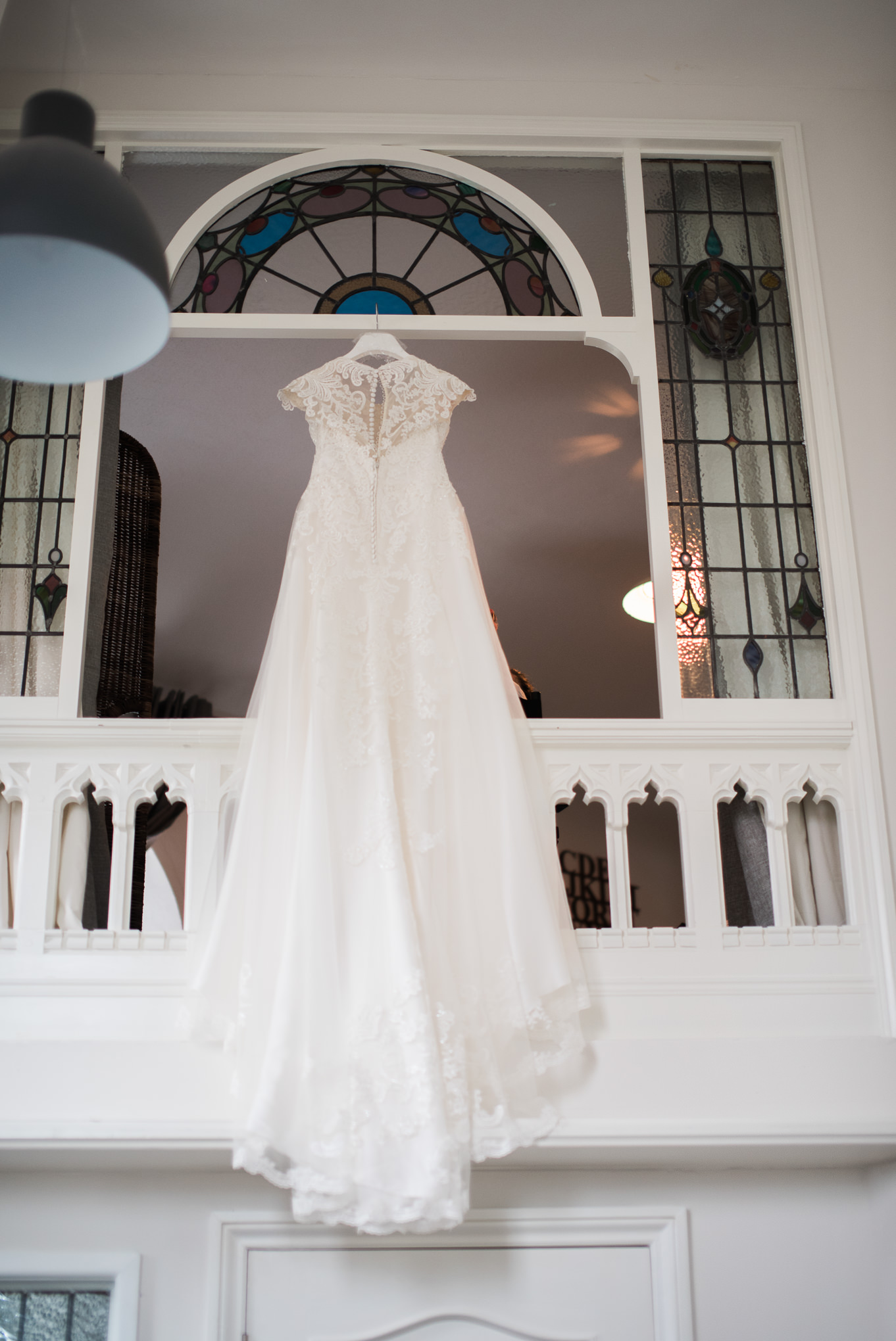 Full length shot of wedding dress hung from a window in the Dreamcatcher.