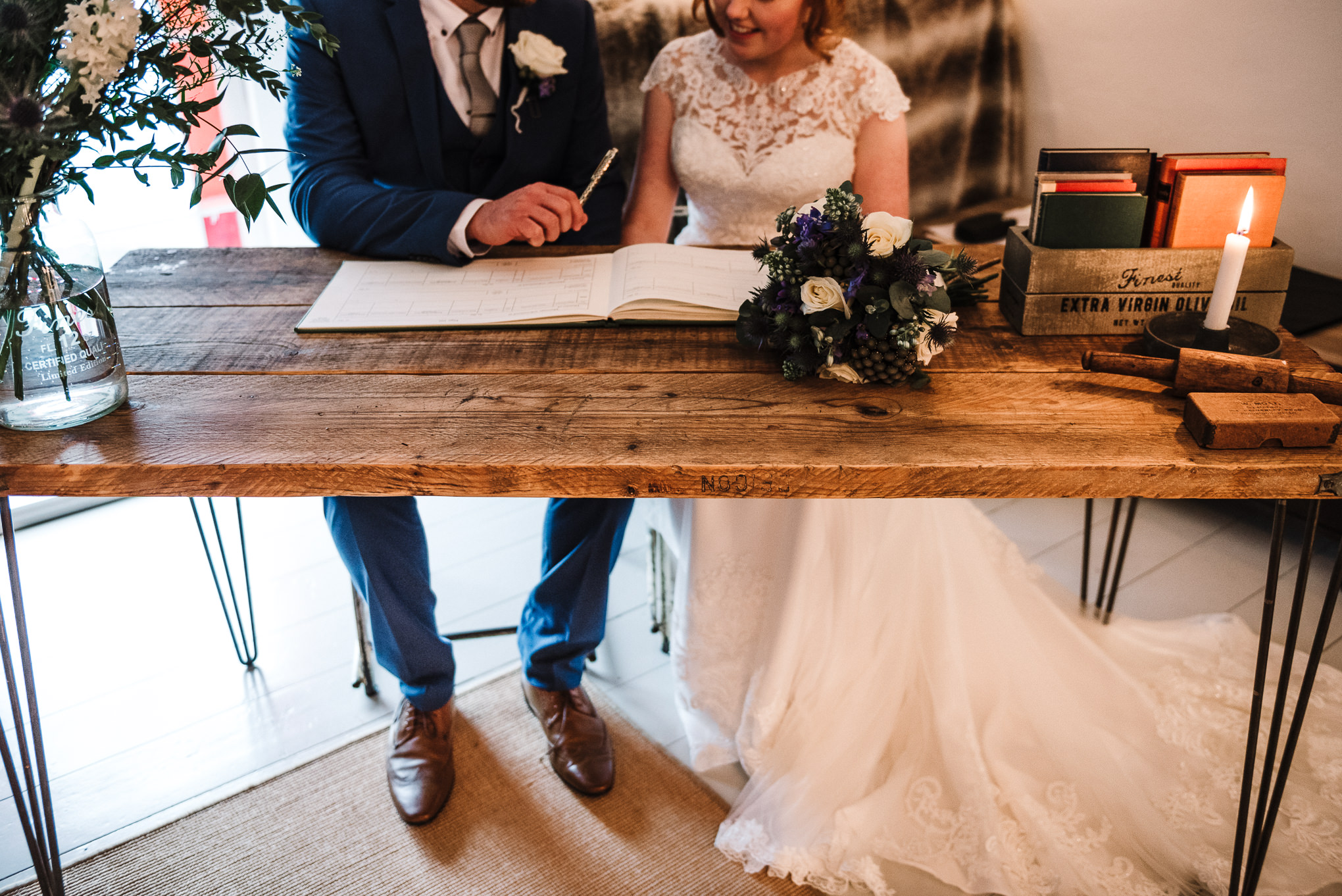 Mordern styled shot of couple signing the wedding register. Elopement wedding photography in Cornwall.