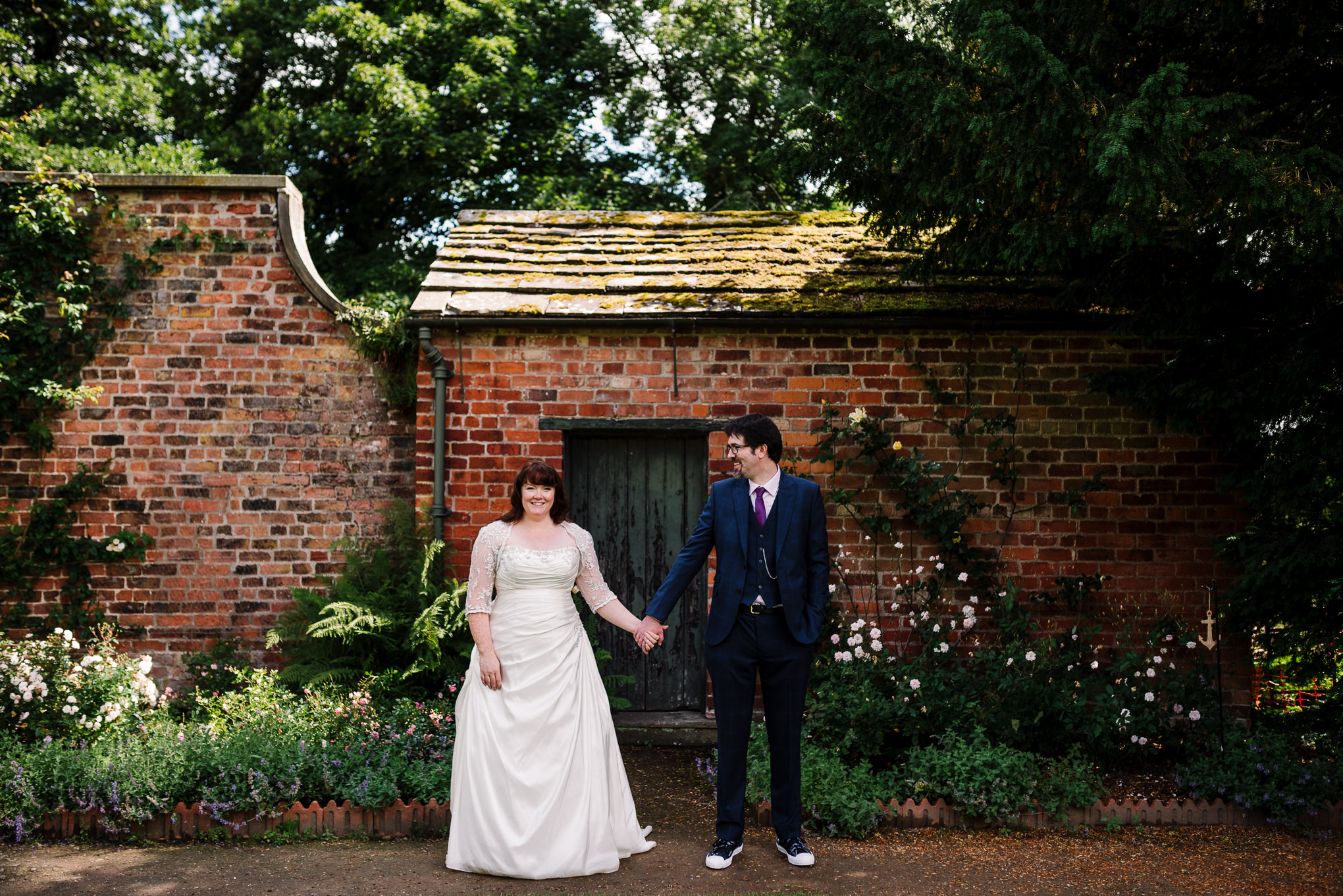 Stood holding hands in the garden. Rufford Old Hall wedding photography.