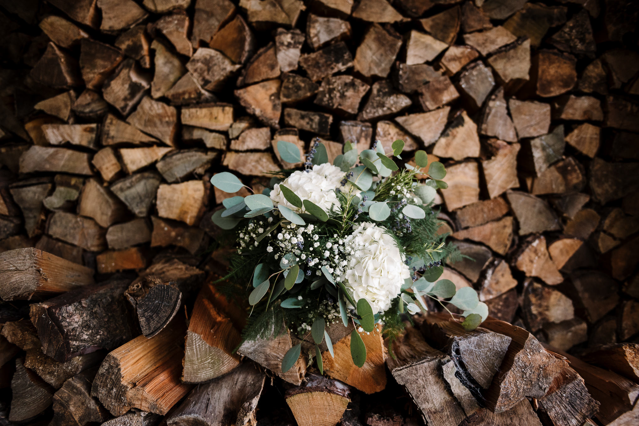 Brides bouquet on log pile. Farm wedding photography