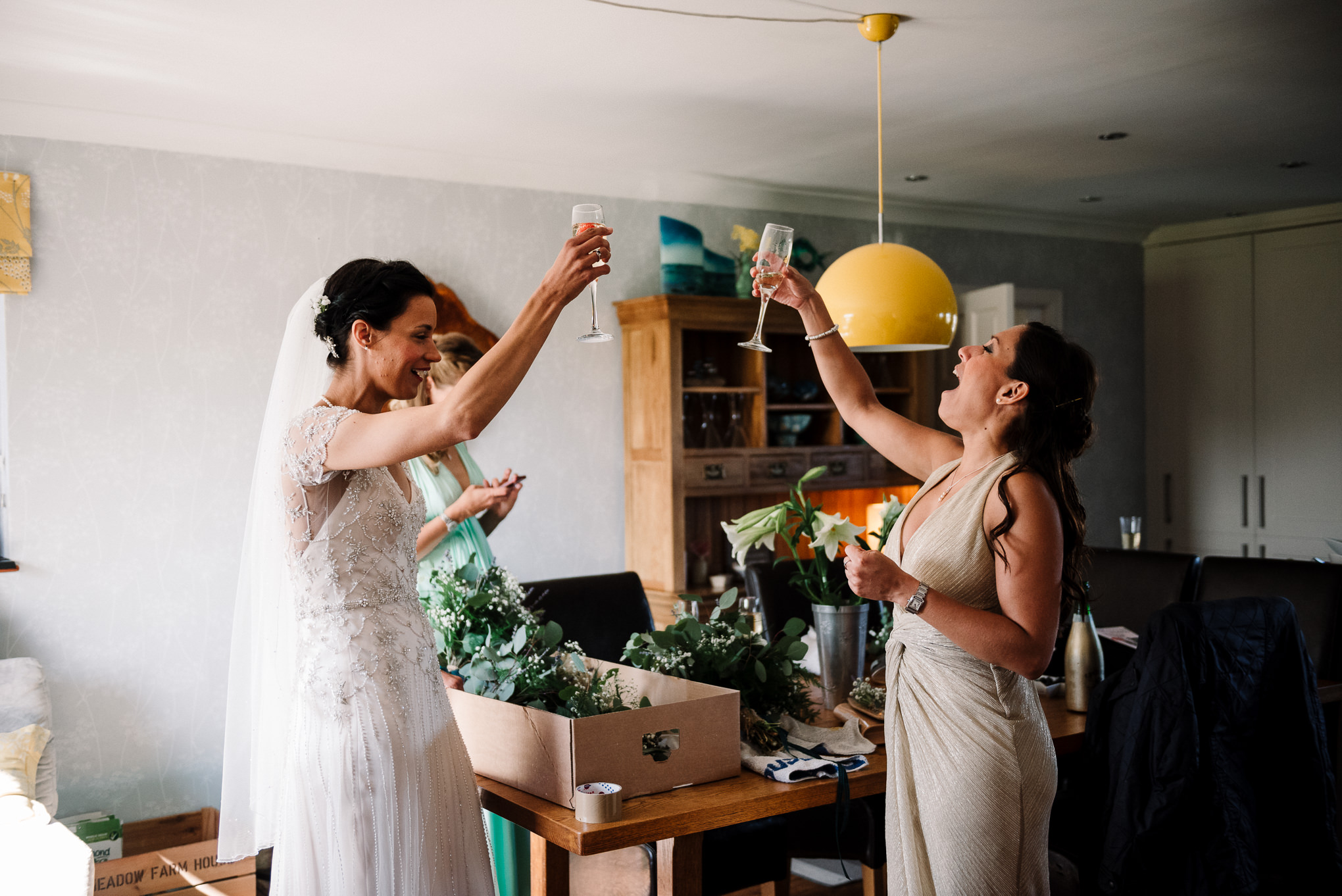 Cheers. Documentary photo of bride and bridesmaid celebrating 