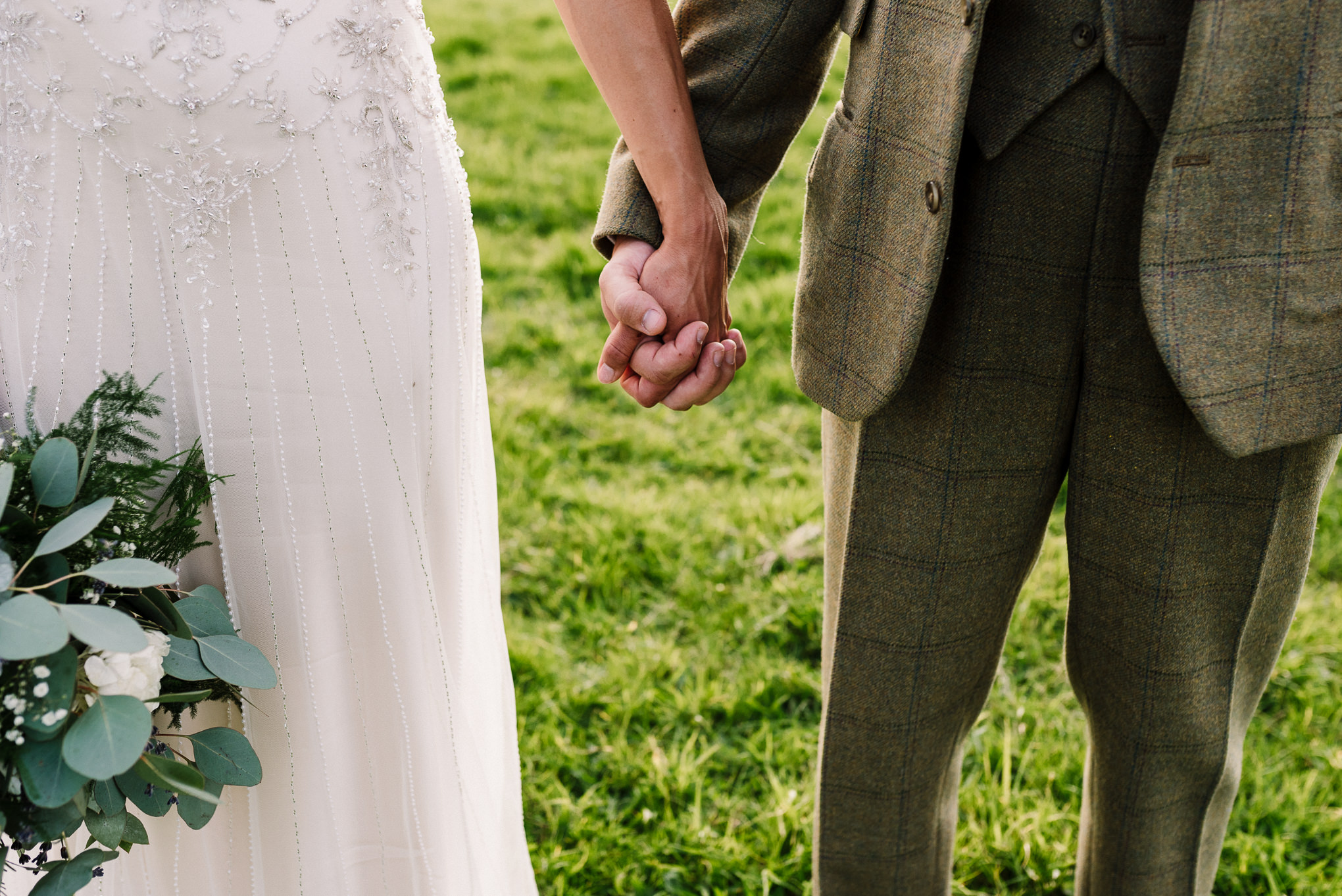 Close up of bride and groom holding hands. Creative wedding photography