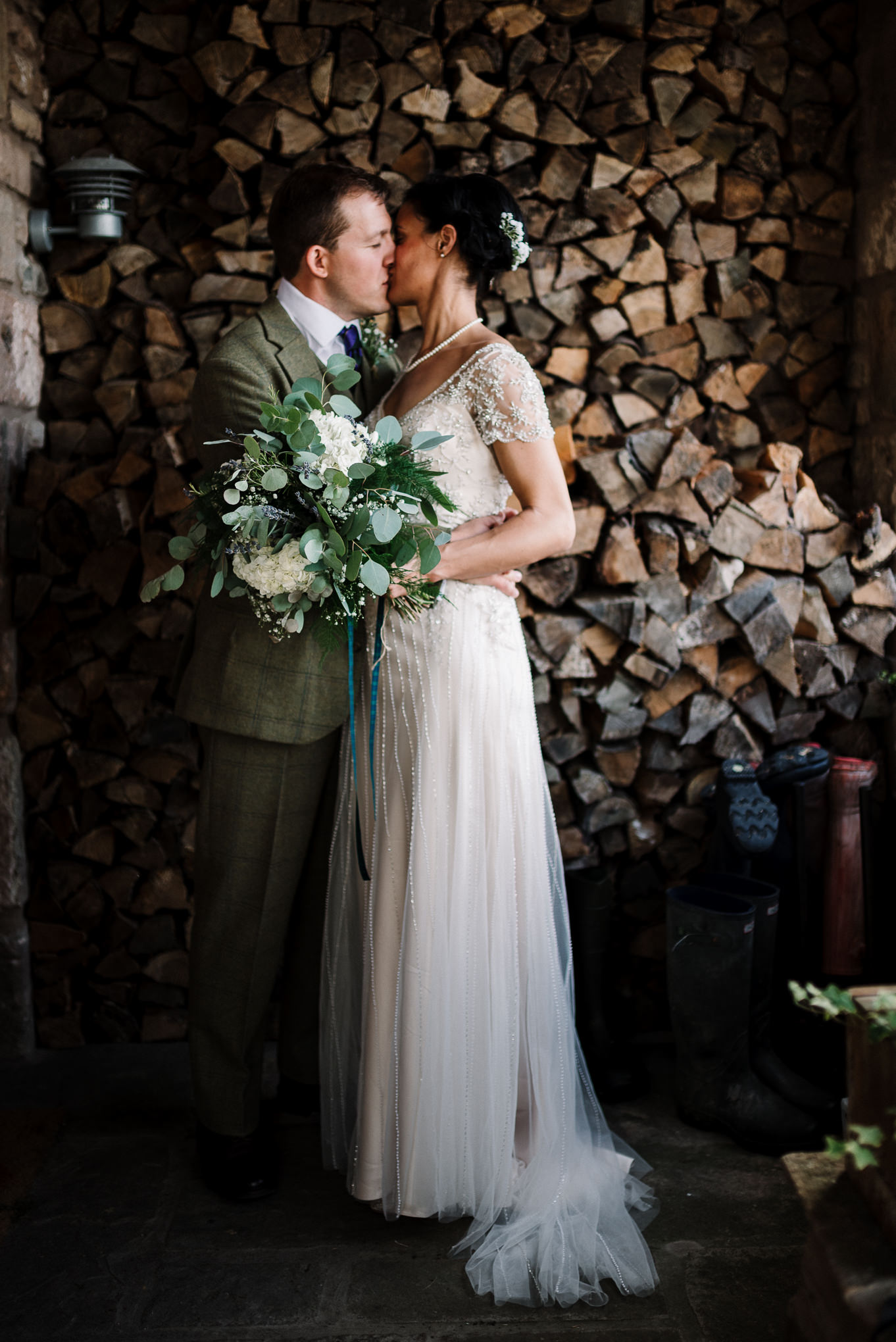 Bride and groom kissing outside the farm house. 