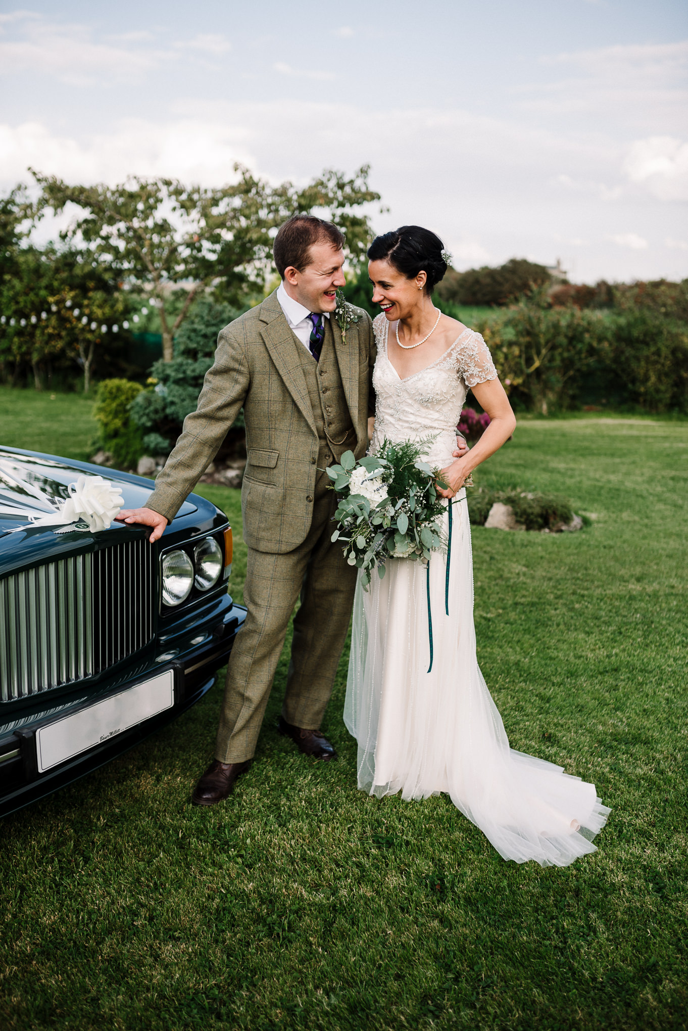 Bride and groom with wedding car. Farm wedding photography