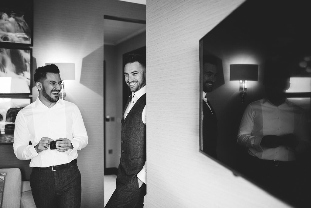 Natural black and White photo of groom and best man laughing. Lancashire wedding photography