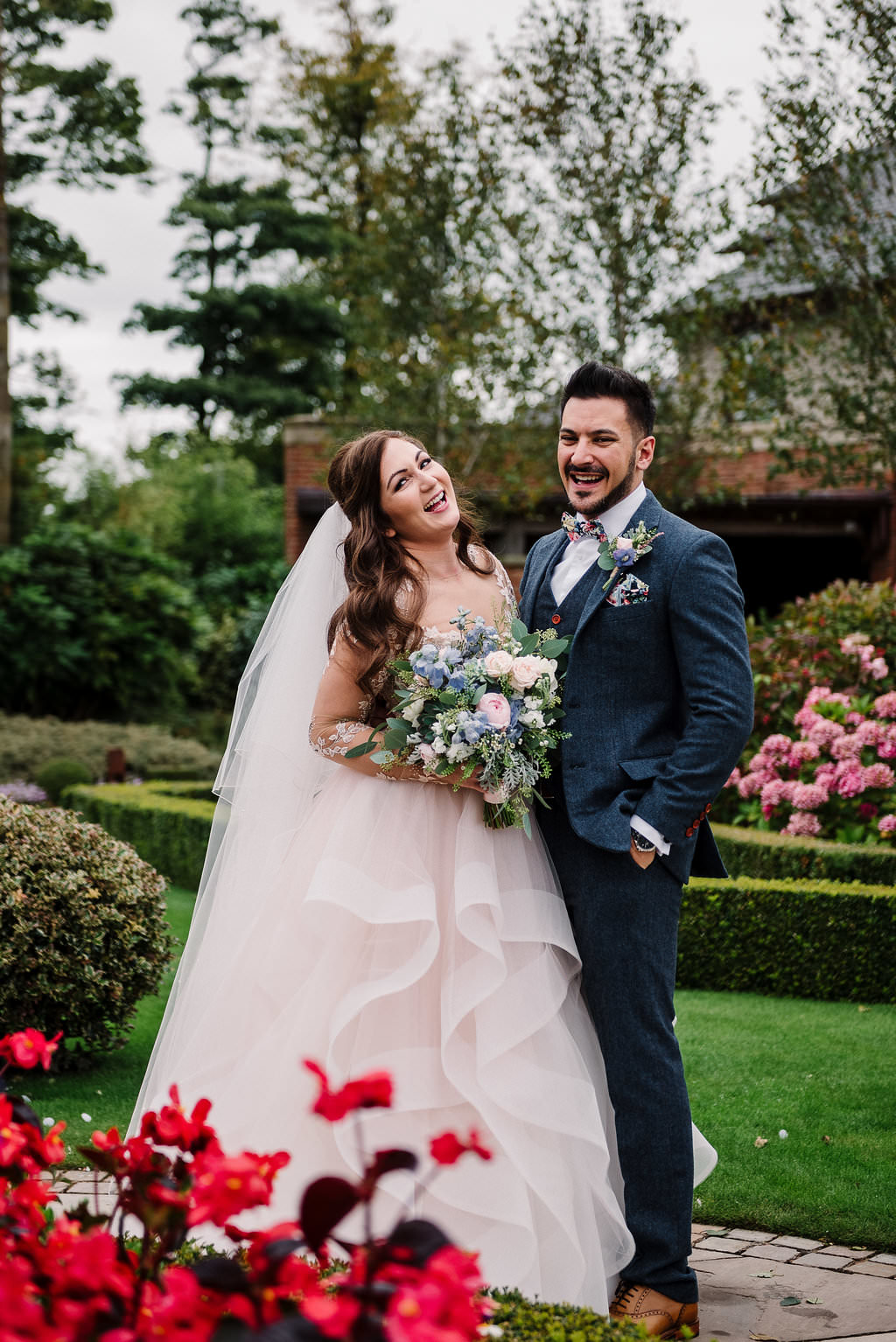 Colourful and relaxed portrait of bride and groom in the gardens at Stanley House Hotel.