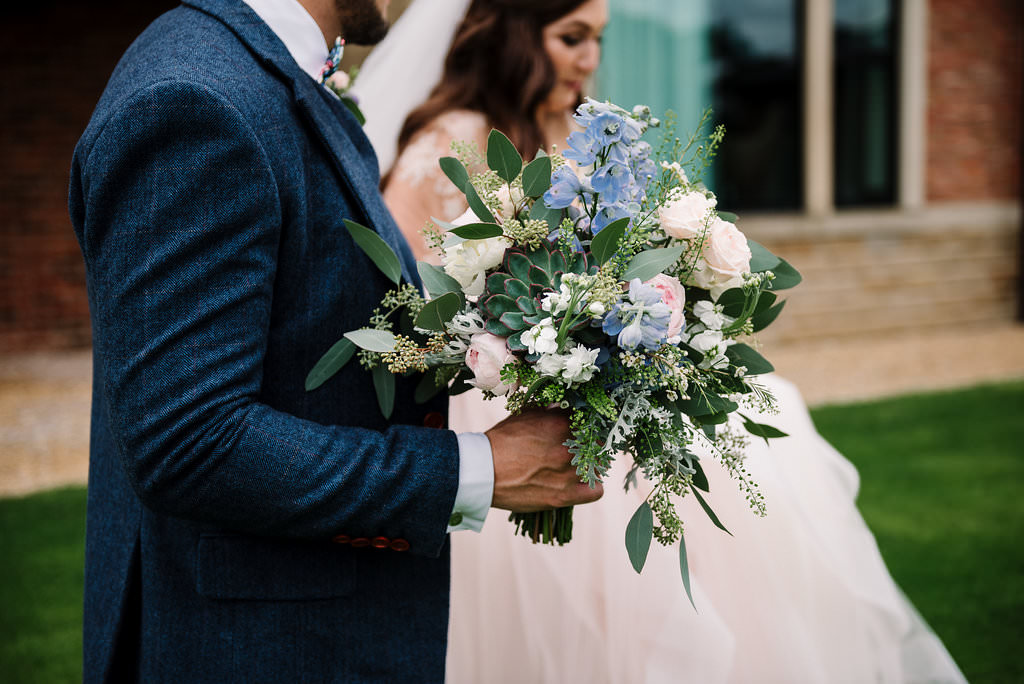 natural shot of bouquet as couple walk.