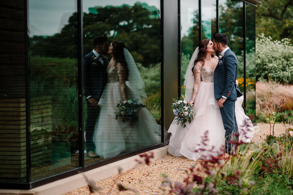 Creative portrait of bride and groom with reflection in a window. Lancashire wedding photography at Stanley House Hotel