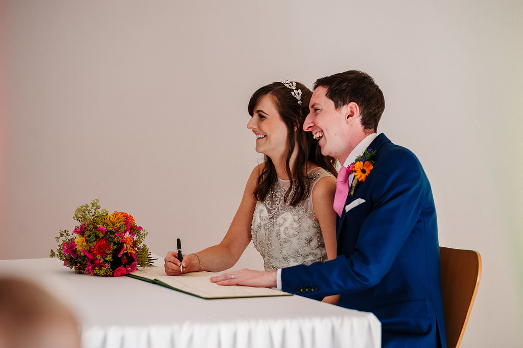 Natural photo of the Bride and Groom signing the register 