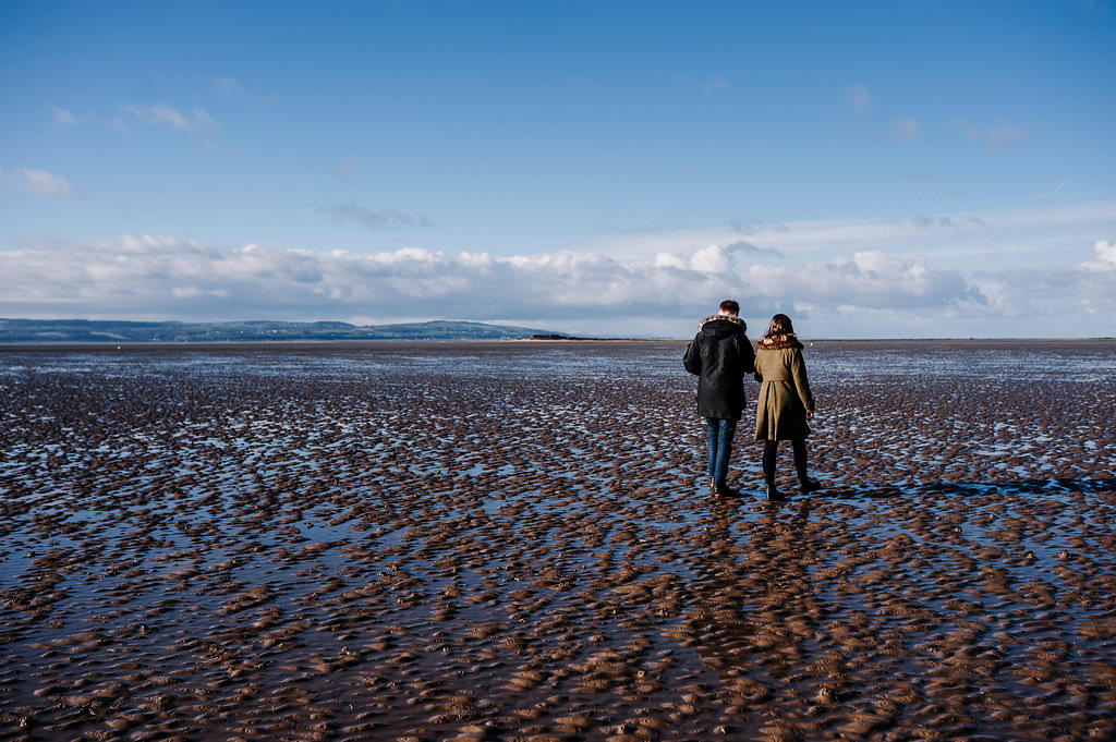 Couple walking along the beach at West Kirby