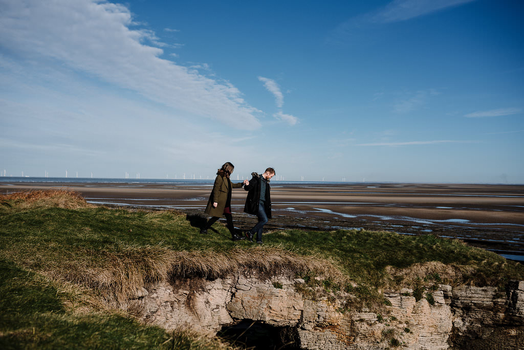 Natural shot of couple walking together on the cliffs at Hilbre Island. West Kirby Photography