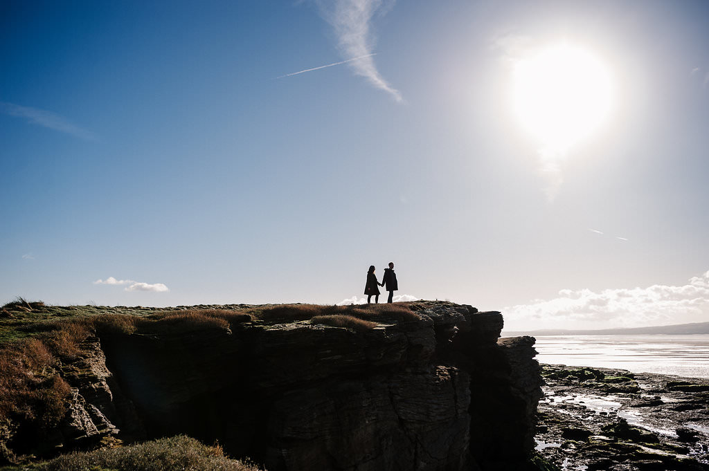 Silhouette of couple stood on cliff top. West Kirby Engagement photography