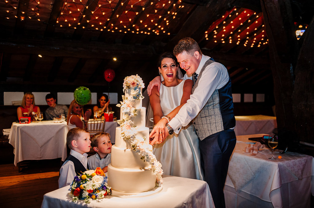 Natural photo of bride and groom cutting their cake.