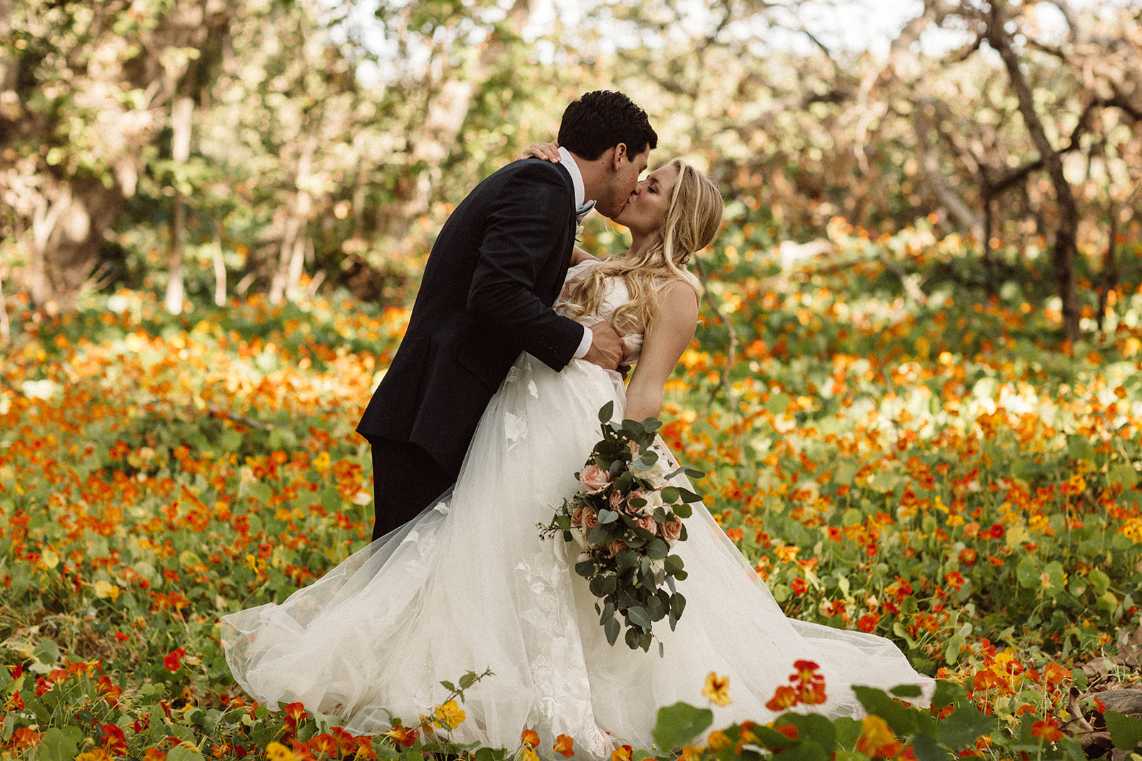 www.santabarbarawedding.com | Isabella Griffith Photography | El Capitan State Beach | KB Events | Alexis Ireland Florals | Bride and Groom Kiss in Field