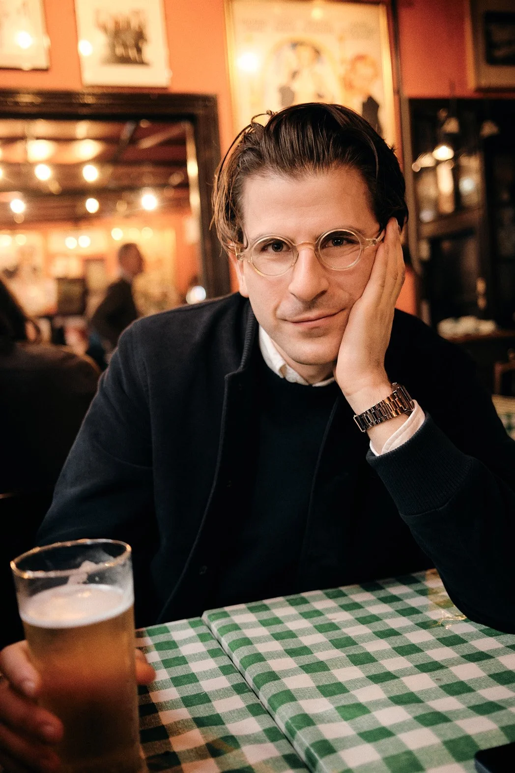 Dating photography portrait of man with pint leaned in for close, intimate portrait.