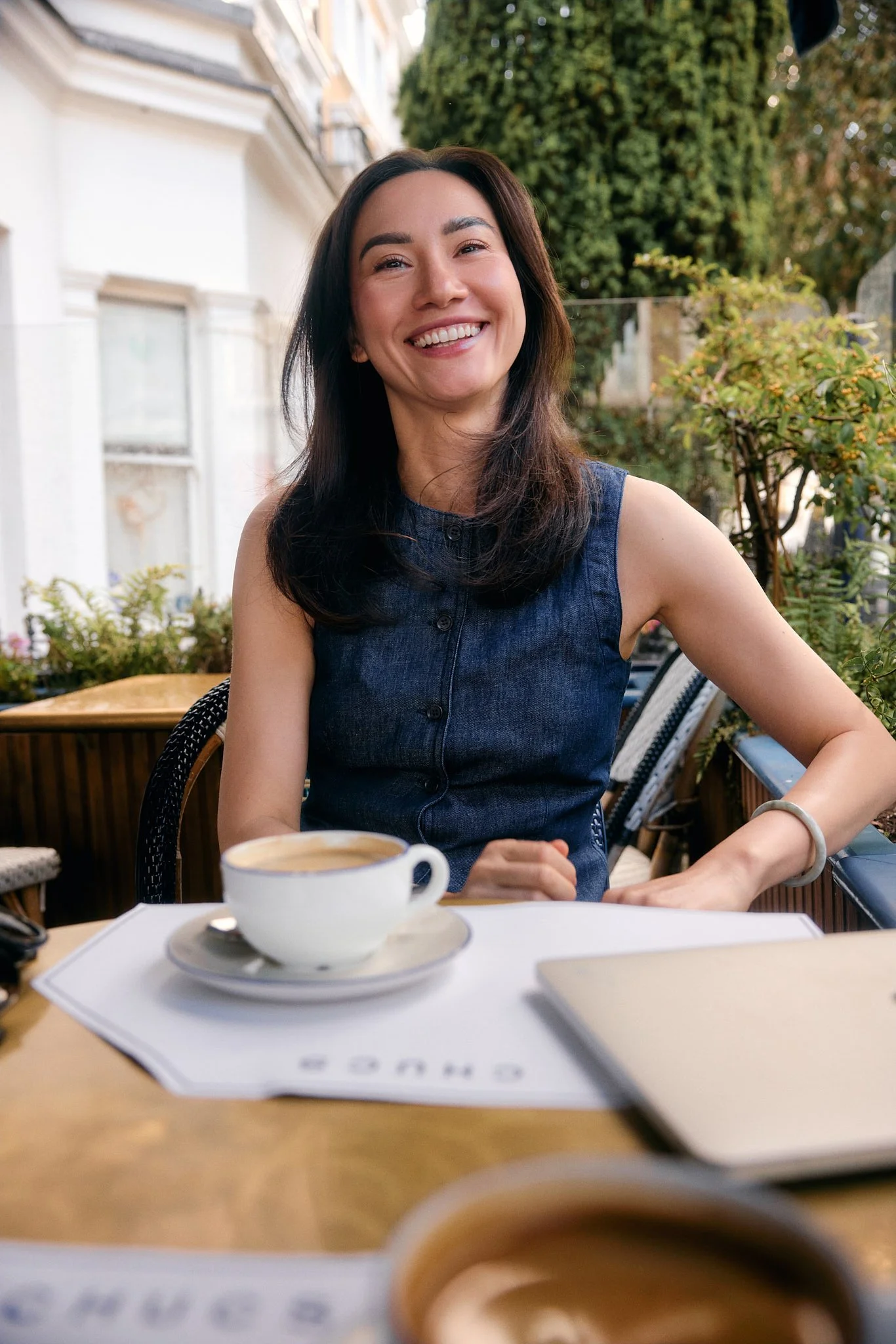 Personal branding photography in London of woman smiling in denim top at café