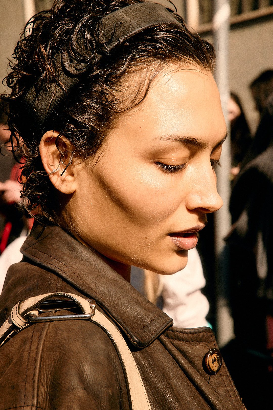 Street style portrait at Milan Fashion Week of short hair model direct sunlight, sharp cheekbones, warm tone