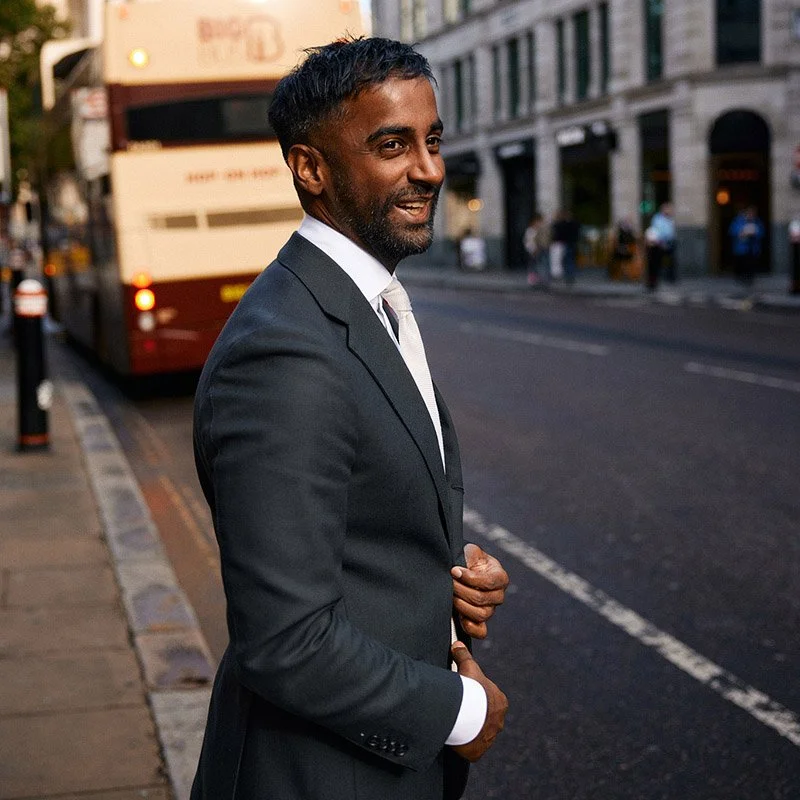 Personal branding photographer in London Ian Kobylanski captures lifestyle portraits of a man in a suit smiling while waiting for a black cab in London