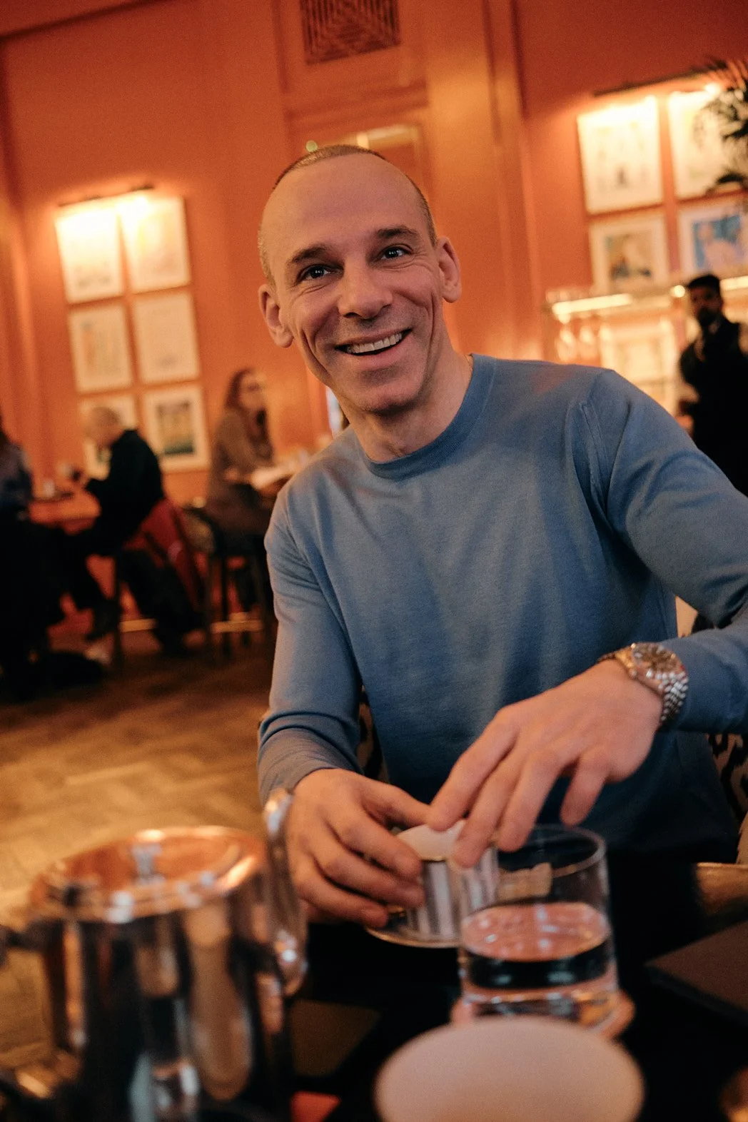 Dating photography portrait of man with tea and drink at upscale bar smiling at camera in candid shot