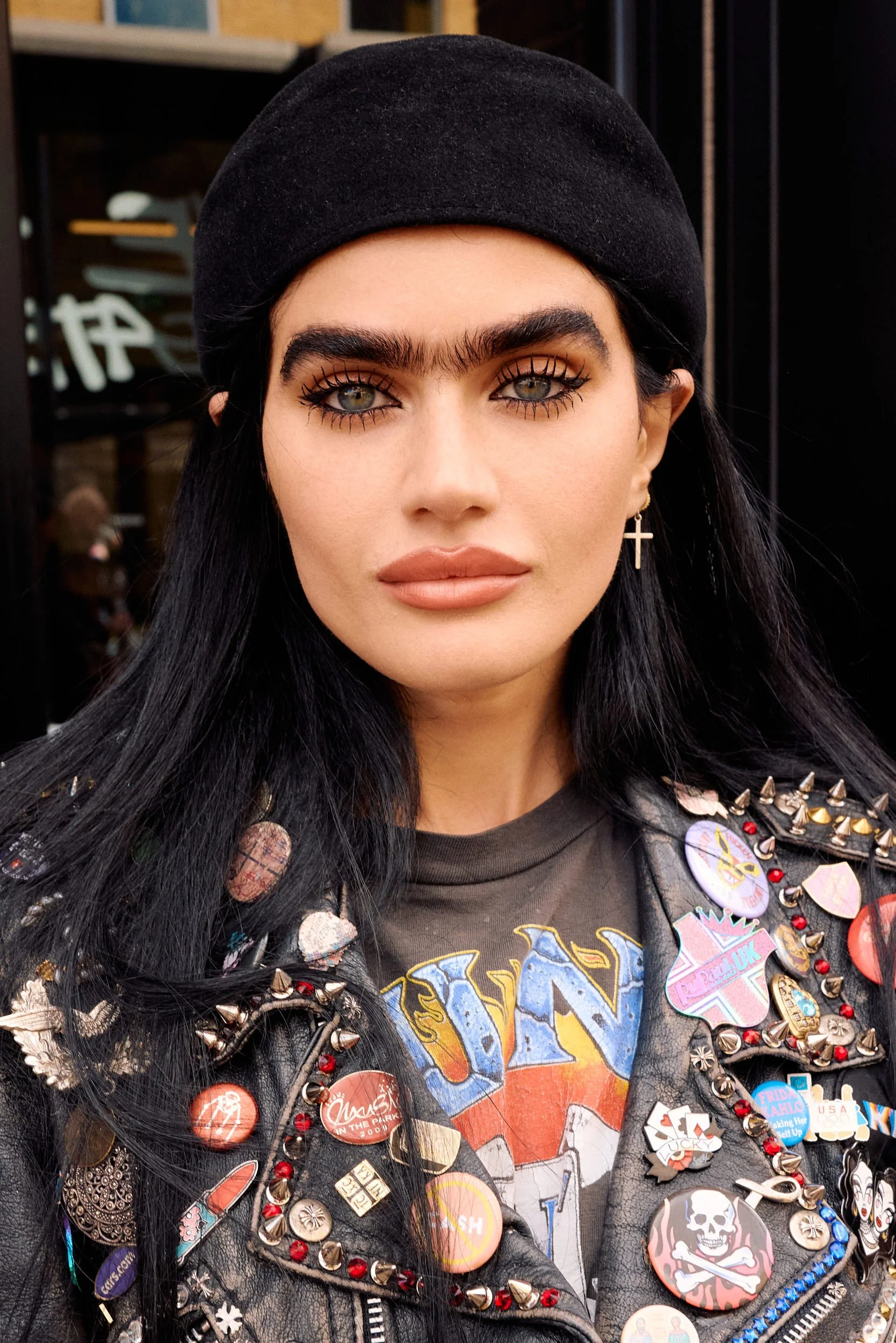 Sophia Hadjipanteli in a black beret and studded leather jacket covered in pin badges at London Fashion Week SS27