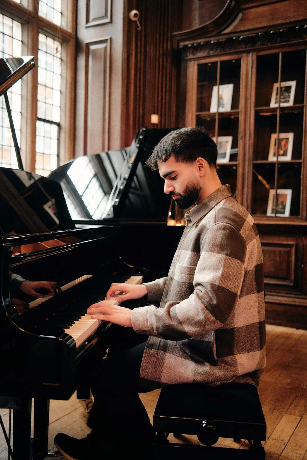 Dating photography portrait of man playing piano in SoHo Yamaha store while concentrated
