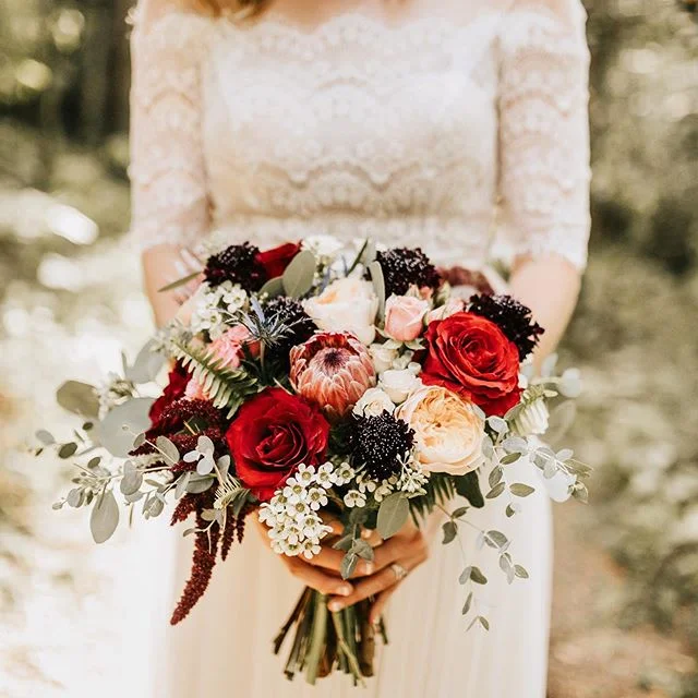 This bouquet couldn’t have been more perfect. I love the pops of color, protea, and how ferns we’re integrated—it fit so perfectly with the setting! 🌿✨