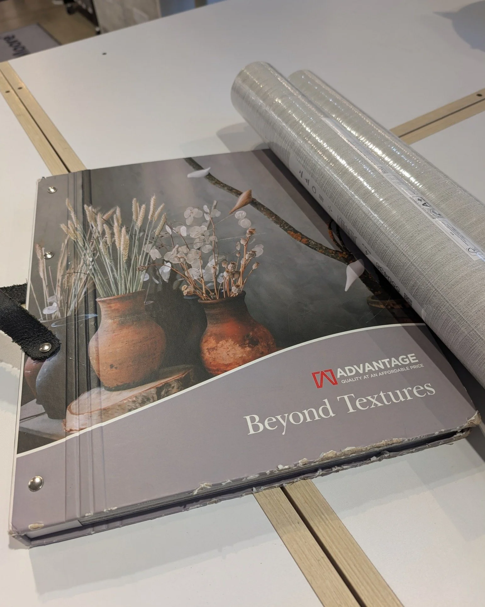 This elegant textural wallpaper adds instant depth to your home. The silver backdrop is laced with thin threads of grey and overlaid with a vertical, feather-like applique of raised inks to create a woven texture.

By: Advantage Brewster Home
Wallpap