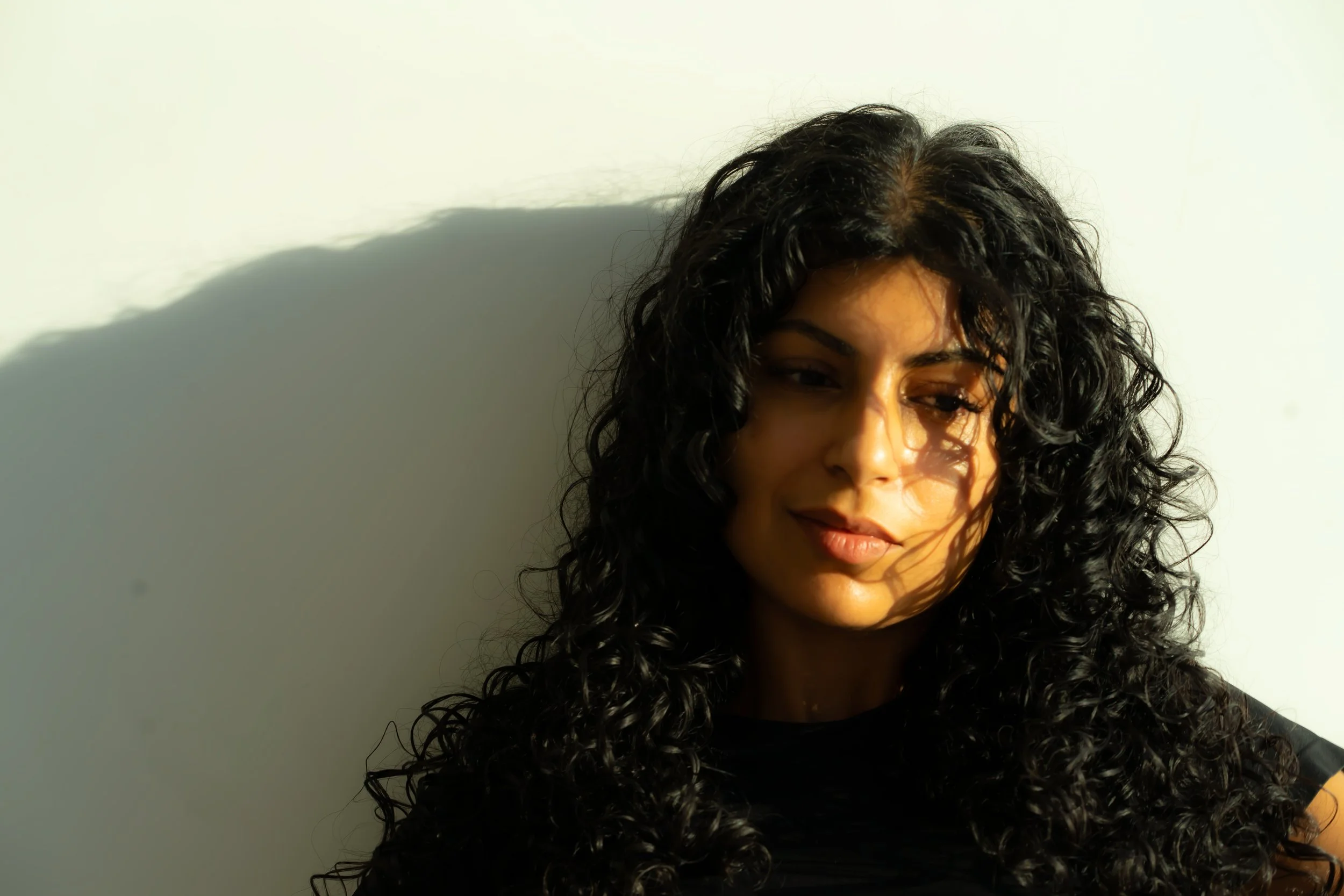 PClose up portrait of a beautiful Pakistani woman looking pensive. Editorial, natural light + flash. Location: Vanity Fair , NYC